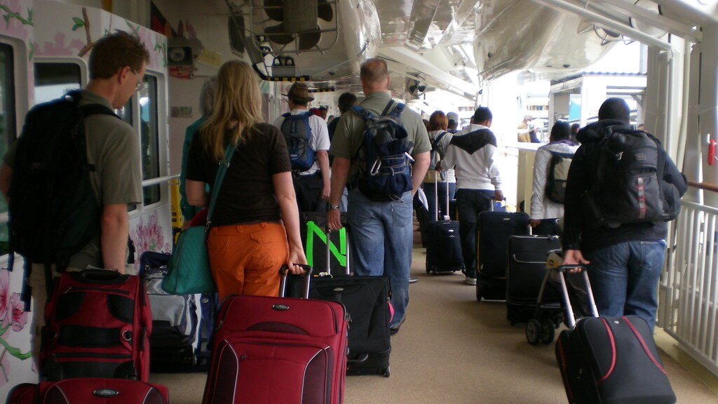 Cruise ship docked at port with passengers disembarking down gangway