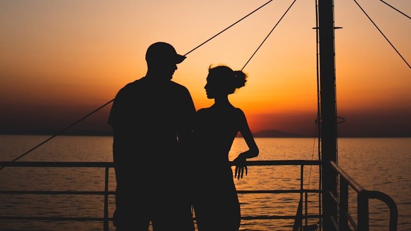 Couple having meaningful conversation on lifestyle cruise deck at sunset, preparing emotionally for social connections