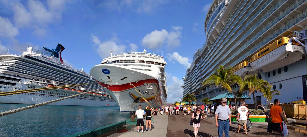 Different cruise ships docked at port showing variety of sizes and cruise lines