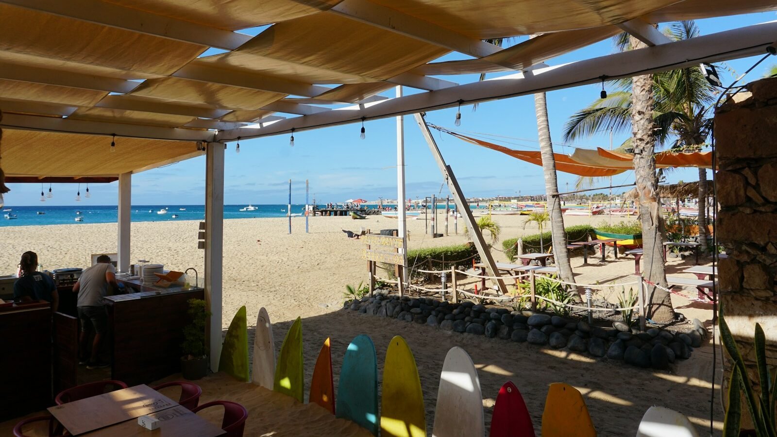 A beachside restaurant with surfboards and beach views.